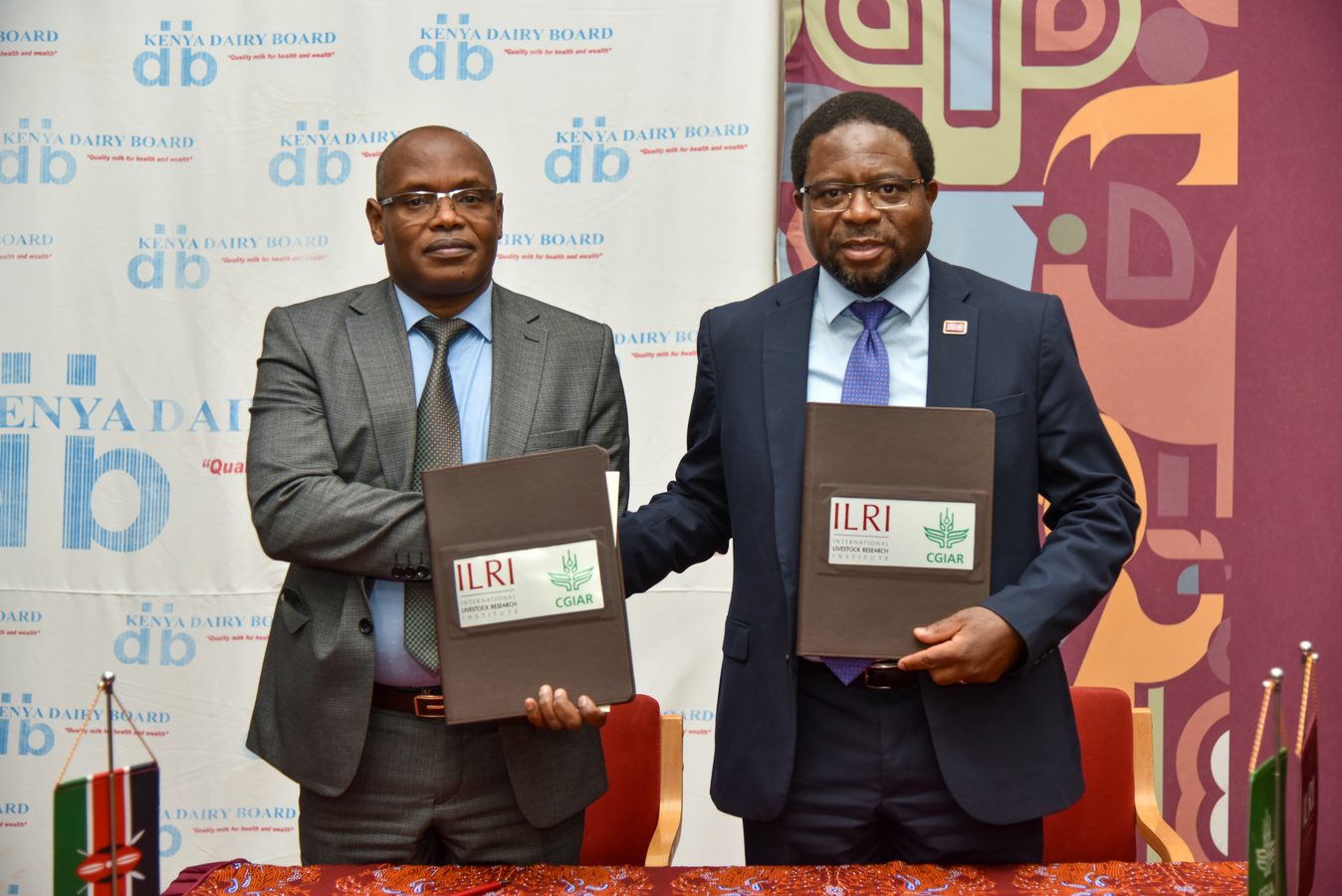 Two officials holding signed agreement folders