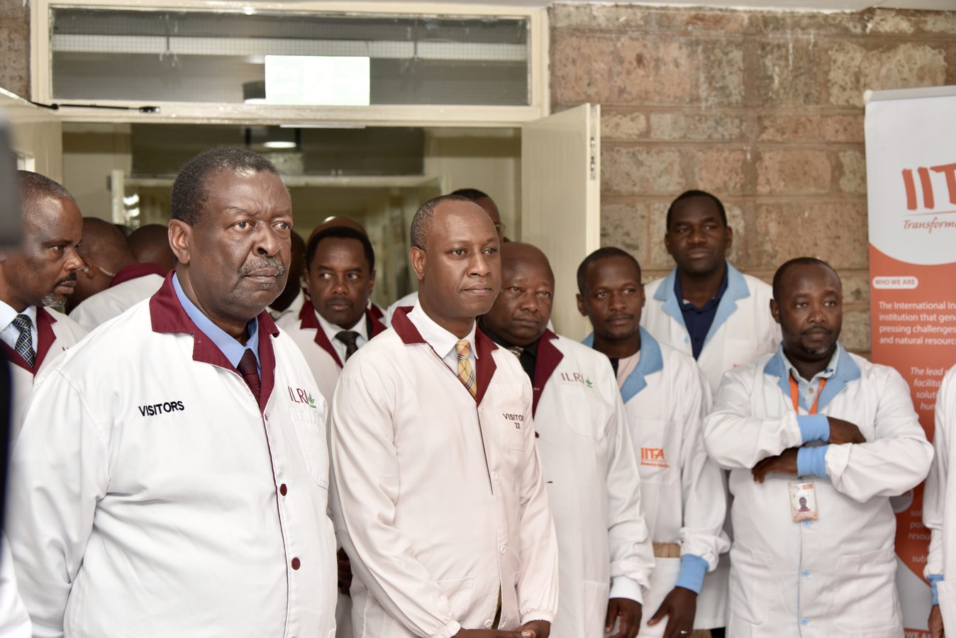 Visitors in laboratory coats during a campus tour